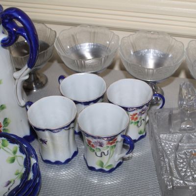 Sale Photo Thumbnail #55: Vintage Japanese hand-painted porcelain tea set featuring cobalt trim and floral motifs, shown alongside pressed glass bowls and silver-tone dessert dishes.