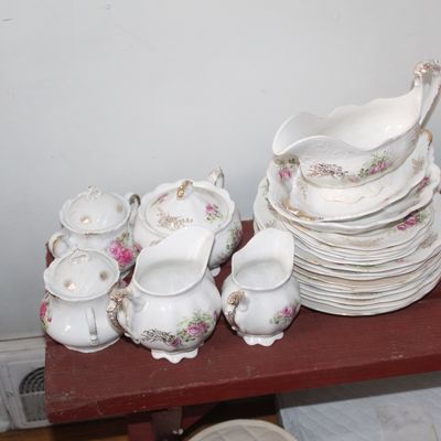 Sale Photo Thumbnail #13: Vintage floral porcelain dinnerware set including gravy boat, pitchers, covered sugar bowls, stack of plates, and pink coasters.