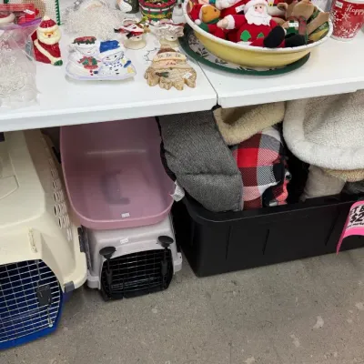 Pet supplies including hard plastic pet carriers, litter boxes, and plush pet beds, along with various Christmas decor items.
