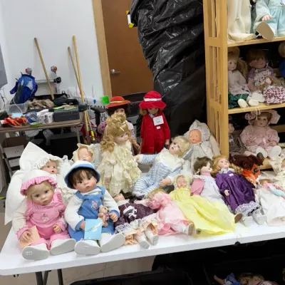 Porcelain and vinyl collectible dolls in various outfits and sizes, including Lee Middleton and Paddington Bear dolls.