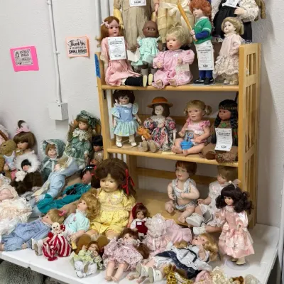 Antique and vintage porcelain, bisque, and composition dolls wearing various period outfits and dresses.