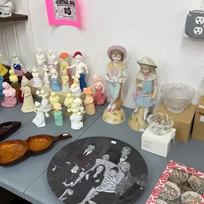 Vintage Avon figurine perfume bottles, large standing child figurines, an Addams Family collector plate, carved wooden divided dishes,...