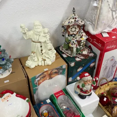 Christmas decorations including ceramic light-up trees, Santa figurines, ornaments in a wicker basket, and holiday dolls.