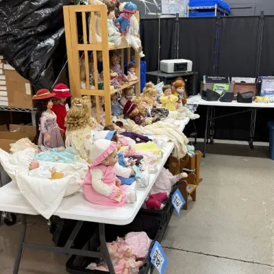 Porcelain dolls and vintage collectible dolls in various outfits.