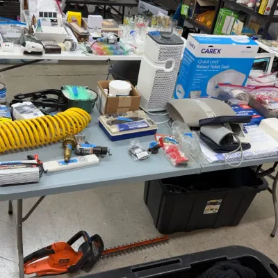 Selection of household items, including a coiled yellow air hose, power tools, medical supplies, and an air purifier.
