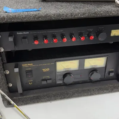 Radio Shack MX-1000 6-channel microphone mixer and a Radio Shack MPA-200 100-watt stereo power P.A. amplifier mounted in a carpeted rack...