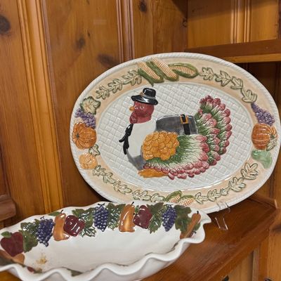 Sale Photo Thumbnail #54: Thanksgiving ceramic serving platter featuring a raised turkey motif and fruit border, shown alongside a scalloped ceramic bowl decorated with painted fruit details.