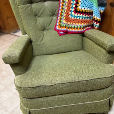 Sale Photo Thumbnail #14: Vintage green upholstered tufted armchair with a colorful crocheted granny square Afghan draped over the back.