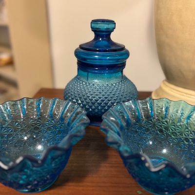 Sale Photo Thumbnail #20: Vintage blue pressed glassware collection including a covered jar with diamond pattern and two ruffled rim bowls.