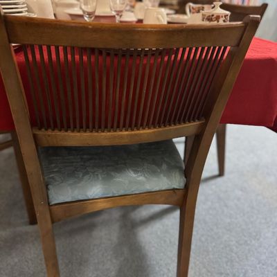 Sale Photo Thumbnail #24: Mid-century wooden dining chair featuring a slender spindle back and light blue patterned fabric seat cushion.