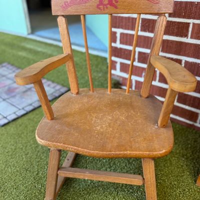 Sale Photo Thumbnail #39: Vintage child's wooden rocking chair featuring a red stencil of a rocking horse and musical notes on the backrest, showing light finish wear.