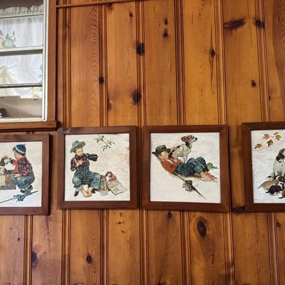 Sale Photo Thumbnail #4: Set of four framed vintage art prints depicting young boys and dogs in rural scenes, housed in matching dark wood square frames.
