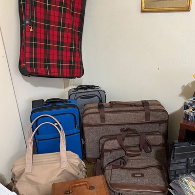Sale Photo Thumbnail #44: Collection of assorted luggage pieces, including a vintage tweed suitcase set, modern rolling bags, a red plaid garment bag, and a tan leather cosmetic case.