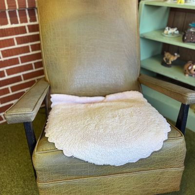 Sale Photo Thumbnail #33: Vintage mid-century vinyl armchair with olive green textured faux-leather upholstery and dark wooden frame, displaying visible surface wear.