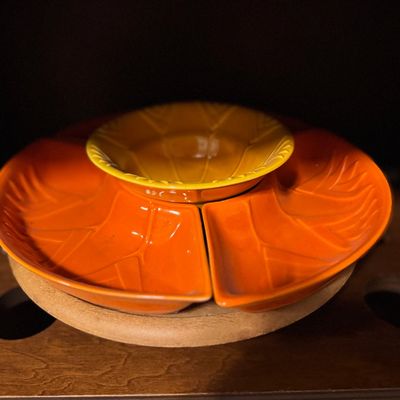 Sale Photo Thumbnail #26: Vintage mid-century ceramic leaf-patterned chip and dip lazy Susan set in orange and yellow glazes, mounted on a rotating wooden base.