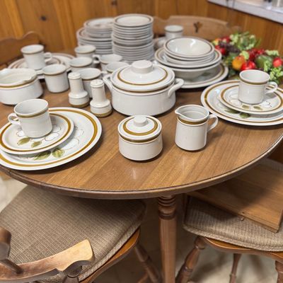 Sale Photo Thumbnail #16: Large vintage stoneware dinnerware set featuring a brown trim and floral motif, displayed on a wooden dining table.
