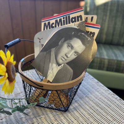 Sale Photo Thumbnail #35: Collection of vintage hand fans displayed in a small wire basket, featuring an Elvis Presley portrait fan and political campaign fans.