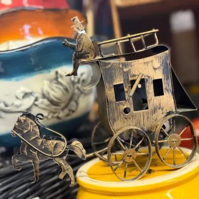 Sale Photo Thumbnail #60: Vintage painted metal horse-drawn stagecoach miniature figurine featuring a driver on top and a distressed black and gold finish.