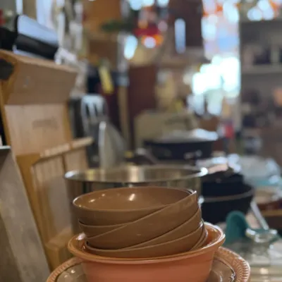 Sale Photo Thumbnail #81: Stack of vintage ceramic kitchen bowls in earth tones and salmon pink, displayed alongside cookware and housewares.