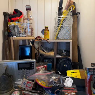 Sale Photo Thumbnail #27: Eclectic shelf display featuring vintage Grundig radio, pocket knives, Hoppe's gun solvent bottle, decorative glassware, and assorted collectibles.