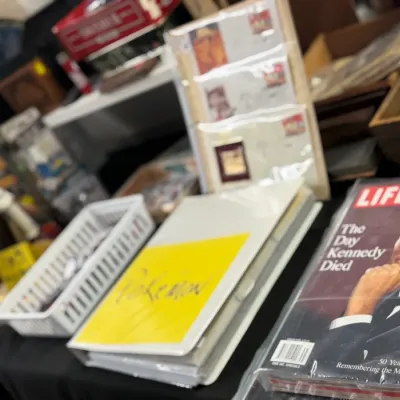 Sale Photo Thumbnail #46: Selection of vintage ephemera and collectibles, featuring a LIFE magazine Kennedy special issue, a Pokémon binder, and framed memorabilia.