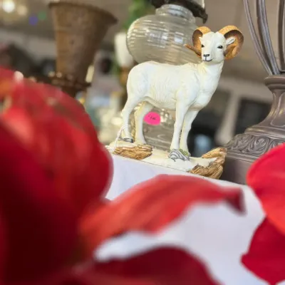 Sale Photo Thumbnail #51: Painted ceramic big horn sheep figurine mounted on a naturalistic base, displayed among household decor items.