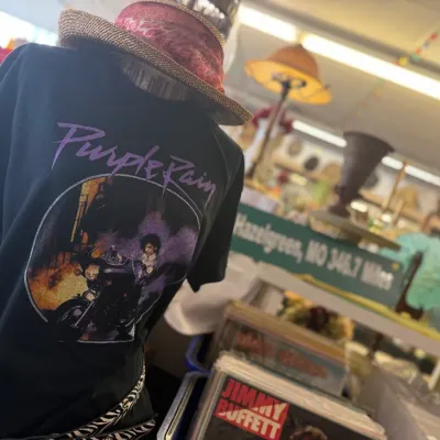 Sale Photo Thumbnail #35: Black Prince 'Purple Rain' graphic t-shirt displayed on a mannequin, topped with a patterned fedora hat.