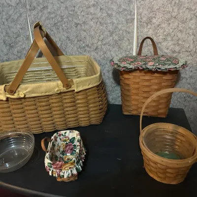 Collection of Longaberger-style woven wood baskets featuring cloth fabric liners, leather handles, and clear plastic protectors.