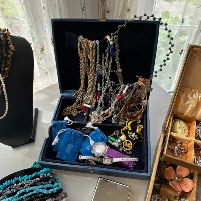 Collection of vintage costume jewelry, including beaded necklaces on a bust, chains in a blue velvet-lined jewelry box, watches,...
