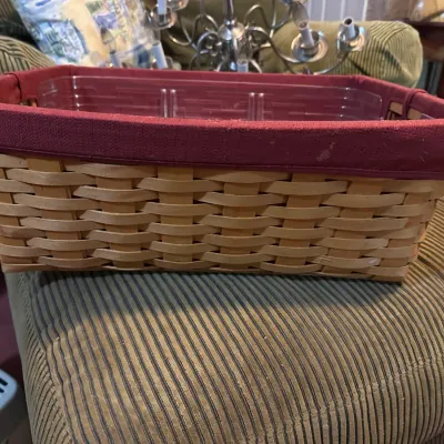 Rectangular woven wood basket featuring a burgundy fabric liner cuff and a plastic protective insert.