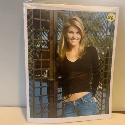 Autographed color promotional photograph of actress Lori Loughlin, signed in black marker and housed in a protective sleeve.