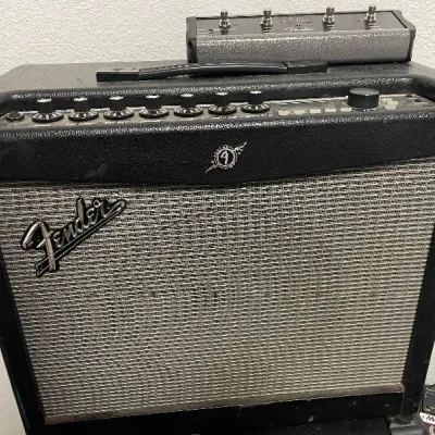 Fender Mustang modeling guitar combo amplifier in black vinyl casing, complete with a top-mounted Fender multi-button footswitch controller.