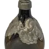 Vintage dark glass decanter with a pewter metal overlay depicting grape clusters and leaves, topped with an ornate matching stopper.