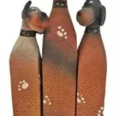 Whimsical ceramic or painted resin trio of dogs figurine featuring stylized elongated bodies with paw print accents.