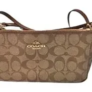Coach Signature canvas crossbody bag with gold-tone hardware and leather trim.