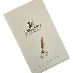 Swarovski Crystal Memories Classics product booklet featuring the swan logo and a quill in inkwell illustration.