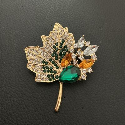 Sale Photo Thumbnail #209: Gold-tone leaf brooch featuring pave set clear, dark green, amber, and light green rhinestones, with larger marquise and teardrop faceted glass stones. Measures approximately 55mm x 50mm. Good condition with all stones intact and bright finish.