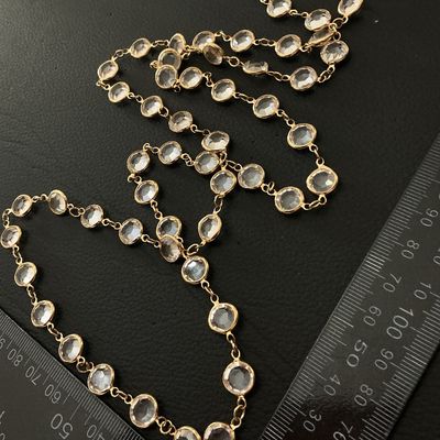 Sale Photo Thumbnail #190: Long gold-tone chain necklace featuring bezel-set round clear crystals or faceted glass stations. Equipped with a lobster claw clasp. Measures approximately 36 to 40 inches long total. In good condition with no missing stones or broken links noted.