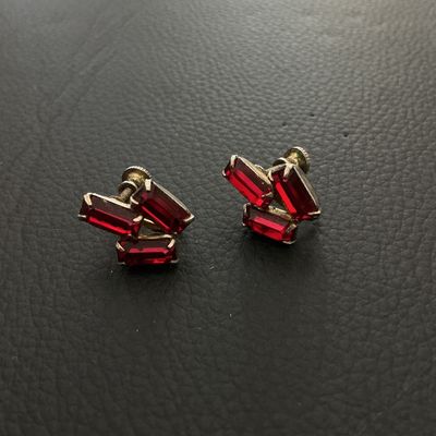 Sale Photo Thumbnail #252: Pair of vintage screw-back earrings featuring red baguette-cut rhinestone clusters in a silvertone or base metal setting. Each earring measures approximately 20mm x 15mm. Shows minor signs of age and wear to the metal finish consistent with age.