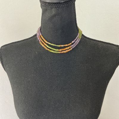 Sale Photo Thumbnail #261: A multi-strand beaded choker necklace featuring small, square cylinder beads in alternating sections of purple, light green, and amber orange. Finished with a gold-tone barrel clasp. In good pre-owned condition with no missing beads visible.