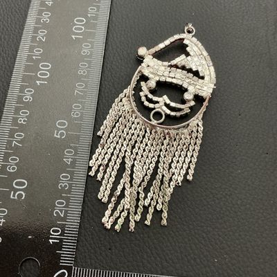 Sale Photo Thumbnail #152: Festive Santa Claus pendant featuring red, clear, and green rhinestones with silver-tone tassel fringe beard. Measures approximately 3.5 inches long (90 mm) by 1.75 inches wide (45 mm). Silver-tone metal backing with a pendant bail at the top. Good condit