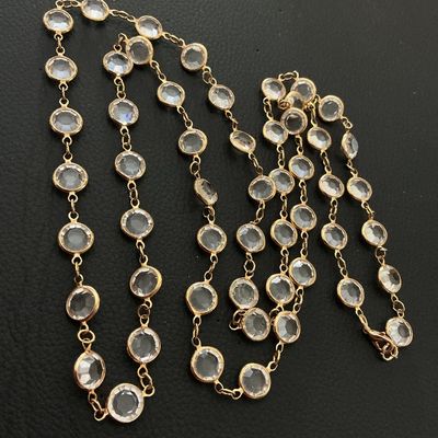 Sale Photo Thumbnail #188: Long gold-tone chain necklace featuring bezel-set round clear crystals or faceted glass stations. Equipped with a lobster claw clasp. Measures approximately 36 to 40 inches long total. In good condition with no missing stones or broken links noted.