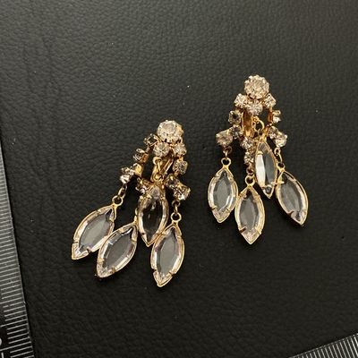 Sale Photo Thumbnail #243: Pair of vintage gold-tone clip-on dangle earrings set with clear round rhinestones and navette/marquise-cut glass stones in dangling drops. Each earring measures approximately 2 inches (50 mm) in length. Shows minor vintage surface wear; all stones are in