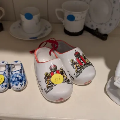 Collection of ceramic souvenir clogs, including a pair adorned with the coat of arms of Amsterdam, alongside Delfts blue style miniature...