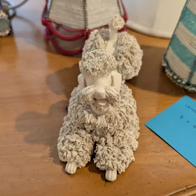 Vintage white spaghetti porcelain poodle figurine featuring textured ceramic fur detailing.