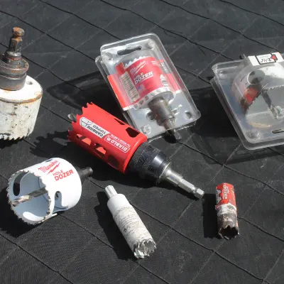 Sale Photo Thumbnail #72: Assortment of hole saws and drill attachments, including Milwaukee Hole Dozer and Diablo carbide-tipped bits in various used and packaged conditions.