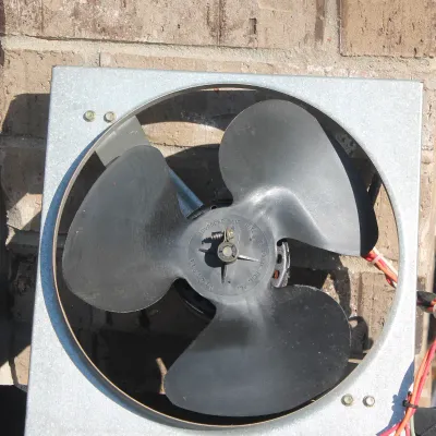Sale Photo Thumbnail #6: Advanced Air Mfg. attic or ventilation exhaust fan with a square galvanized metal frame and black three-blade impeller.