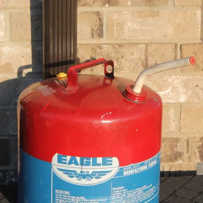 Sale Photo Thumbnail #19: Vintage Eagle Manufacturing Co. 5-gallon red and blue metal gasoline safety can, model KES-5, featuring a top carrying handle and flexible pour spout.