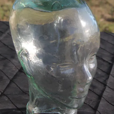 Sale Photo Thumbnail #12: Vintage life-size clear glass mannequin head with subtle greenish tint and molded facial features.