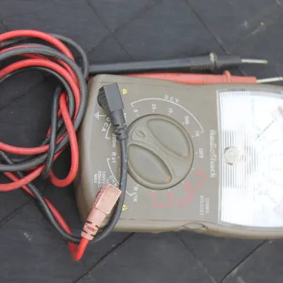 Sale Photo Thumbnail #73: Vintage RadioShack analog multimeter with red and black test leads, showing typical light cosmetic wear.